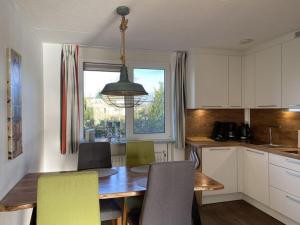een keuken met een tafel en stoelen en een raam bij Villa Zeezicht Modern retreat in Makkum