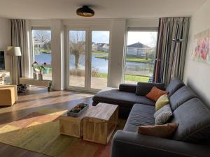 sala de estar con sofá y mesa en Villa Zeezicht Modern retreat, en Makkum