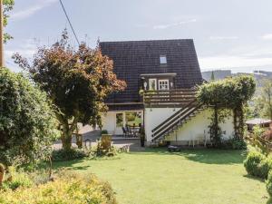a small white house with a porch and stairs at Dreamy apartment near forest in Eslohe