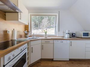 a kitchen with white cabinets and a window at Dreamy apartment near forest in Eslohe