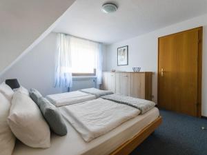 um quarto com uma cama com lençóis brancos e uma janela em Sunny slope type G em Eslohe