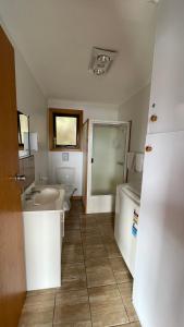 a bathroom with a sink and a toilet and a bed at Sunset Holiday Villas in Arthur River