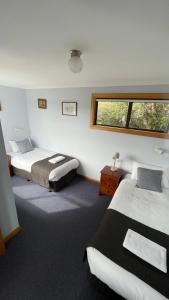a bedroom with two beds and a window at Sunset Holiday Villas in Arthur River