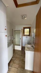 a bathroom with a sink and a tub and a toilet at Sunset Holiday Villas in Arthur River