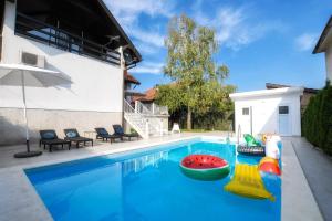 ein Pool mit Poolspielzeug in einem Haus in der Unterkunft Villa Mina Kladovo, entire charming house with 5 bedrooms in Kladovo