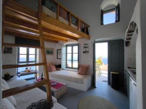 una camera con 2 letti a castello e una cucina di Elias Cave House 270o Caldera View Oia a Oia