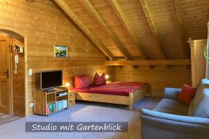 Zimmer mit einem Bett und einem TV in einer Hütte in der Unterkunft Ferienwohnungen Bernie Schmid in Sonthofen