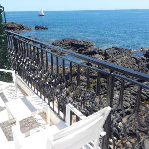 un banco blanco en un balcón con vistas al océano en Hotel Orpheus, en Giardini Naxos