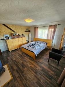 1 dormitorio con 1 cama grande y 1 silla en Casa Grad, en Vişeu de Sus