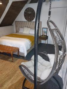 een slaapkamer met een bed en een schommel bij The Gallery Guest House in Port Elizabeth