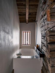 a bath tub in a room with a window at Green Chalet from Centuries ago in Reith bei Kitzbühel