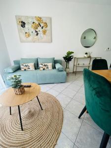 een woonkamer met een blauwe bank en een tafel bij Apartments Angelo in Bibinje