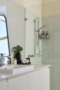biała łazienka z prysznicem i umywalką w obiekcie Victoria Hotel Toodyay w mieście Toodyay