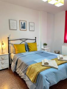 ein Schlafzimmer mit einem großen Bett mit gelben Kissen in der Unterkunft UIM Mediterraneo Diagonal 16 Wfi in Puerto de Sagunto