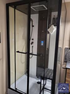 una ducha de cristal con banco en una habitación en Hébergement avec SPA privatif, en Loos-en-Gohelle 4 fotos más