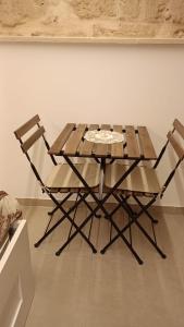 a wooden table and two chairs in a room at IL CORTILETTO in Bari