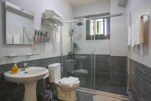 een badkamer met een douche, een toilet en een wastafel bij 里舍民宿 in Jincheng