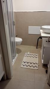 a bathroom with a toilet and a sink and a rug at IL CORTILETTO in Bari
