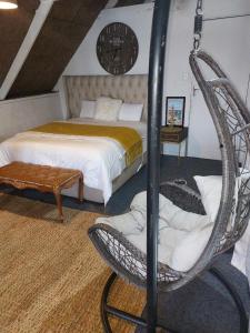 a bedroom with a bed and aokedokedoked chair in a room at Gallery Guesthouse (La Sky Villa) in Gqeberha