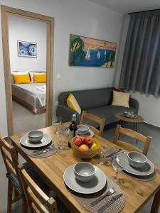a dining table with a bowl of fruit and a living room at modern apt near Heraklion city & airport in Néa Alikarnassós