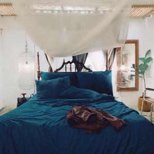ein Bett mit blauer Decke in einem Schlafzimmer in der Unterkunft Tre House Dalat in Da Lat