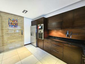 eine Küche mit Holzschränken und einem Kühlschrank in der Unterkunft Dom z Basenem i Sauna Zewnętrzna in Jaszkotle