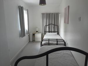 2 camas en una habitación blanca con ventana en Apartment in Historic Mill, near Dover Port en Kent