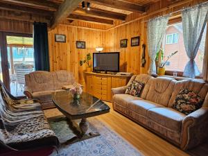 a living room with two couches and a television at Ferienhaus "BASTEK1" am See mit Kamin & WLAN - Domek Letniskowy BASTEK in Pasym