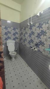 łazienka z toaletą i niebiesko-białymi kafelkami w obiekcie HOTEL MEERA w mieście Bettiah