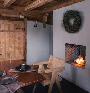 a dining room with a table and a fireplace at Green Chalet from Centuries ago in Reith bei Kitzbühel