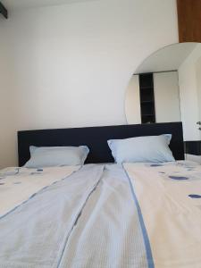 1 cama grande con sábanas blancas y almohadas azules en 3 Zimmer Wohnung, en Maria Lanzendorf