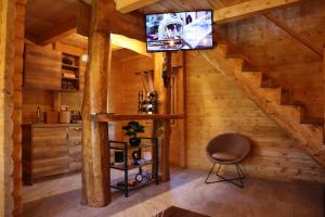 a living room with a television in a log cabin at Green Field Apartments in Virpazar