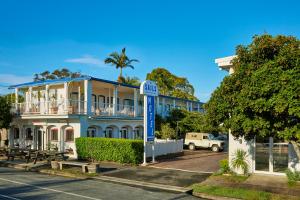 a building with a blue sign in front of it at The Sails Motel Brunswick Heads in Brunswick Heads