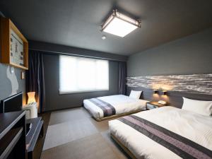 a hotel room with two beds and a window at Iga Ueno City Hotel in Iga