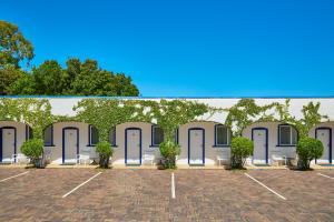 a rendering of a building with doors and trees at The Sails Motel Brunswick Heads in Brunswick Heads