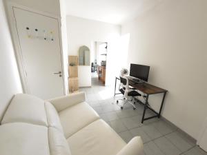 ein Wohnzimmer mit einer weißen Couch und einem Schreibtisch mit einem Computer in der Unterkunft Palais Porte de France Apartment With Air conditionner in Antibes