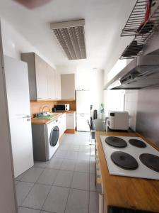 eine Küche mit weißen Schränken und einem Herd mit Backofen in der Unterkunft Palais Porte de France Apartment With Air conditionner in Antibes