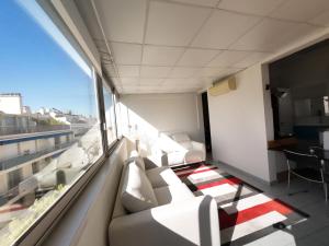 ein Wohnzimmer mit einer Couch und einem Fenster in der Unterkunft Palais Porte de France Apartment With Air conditionner in Antibes