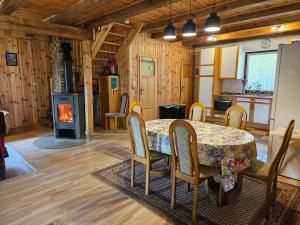 a kitchen and dining room with a table and chairs at Ferienhaus "BASTEK1" am See mit Kamin & WLAN - Domek Letniskowy BASTEK in Pasym