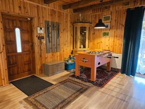 Zimmer mit Holzwänden, einem Schreibtisch und einer Tür in der Unterkunft Ferienhaus "BASTEK1" am See mit Kamin & WLAN - Domek Letniskowy BASTEK in Pasym