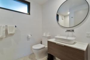 bagno bianco con lavandino e specchio di Victoria Hotel Toodyay a Toodyay