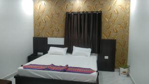 Hazārībāg的住宿－Hotel Alakhraj Palace，一间卧室配有一张白色的床和黑色床头板