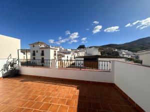 a balcony with white buildings and a blue sky at ATICO BUENAVISTA in Ardales