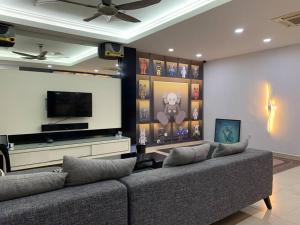 a living room with two couches and a flat screen tv at Johor home in Johor Bahru