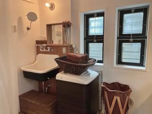 a bathroom with a sink and a mirror and a basket at Good Space Hotel Yoyogi in Tokyo