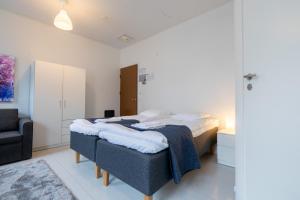 a bedroom with a large bed and a chair at Vanha Postitalo in Varkaus +84 photos