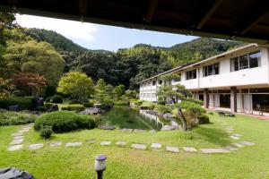 a building with a pond in front of a garden at Ichinomata Onsen Grand Hotel in Shimonoseki