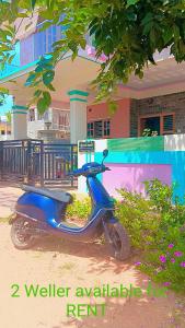 una moto azul estacionada frente a un edificio en Kailash Guest Home en Mysore