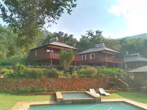 un groupe de maisons avec une piscine dans une cour dans l'établissement Faith Cabin, à Waterval-Onder 18 autres photos