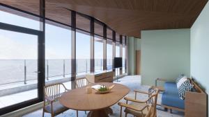 Cette chambre dispose d'une grande fenêtre et d'une table avec des chaises. dans l'établissement Nikko Style Niseko HANAZONO, à Kutchan
